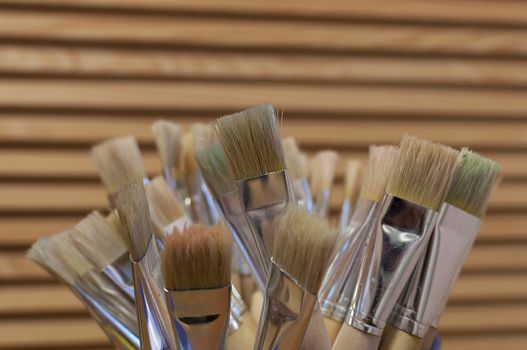 Painting brushes with a wood cabinet in the background