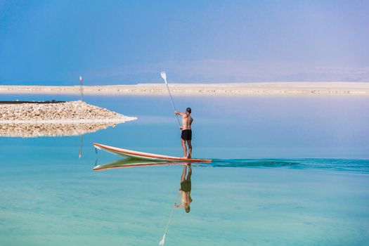 man floats on a boat in the dead sea