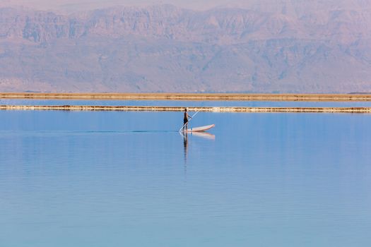 man floats on a boat in the dead sea