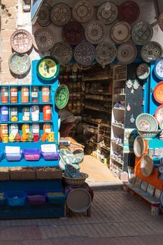 Moroccan shop with displayed ceramics plates and various kinds of spices.