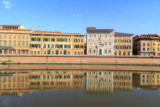PISA, ITALY - SEPTEMBER 21, 2015 : View of historical buildings along the river in Pisa, Italy on bright blue sky background.