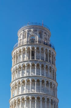 View of historical Pisa Tower in Cathedral Square of Pisa, Italy, on bright blue sky background.