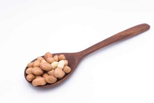 Peanut in wooden spoon on white background