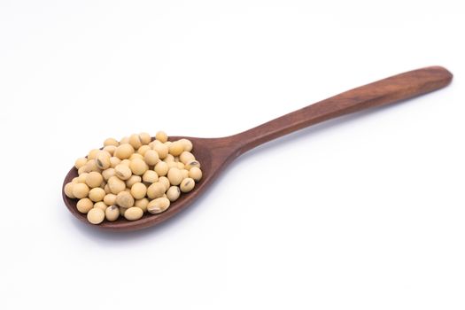 Soy beans in wooden spoon isolated on white background