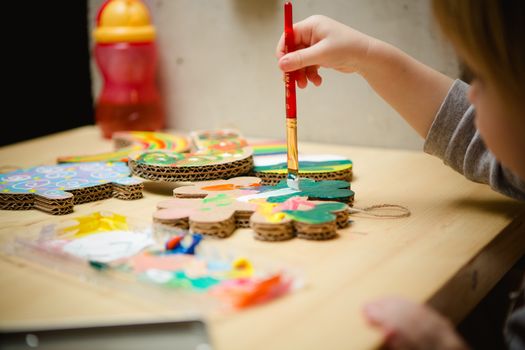 Little female baby painting with colorful paints. selective focus