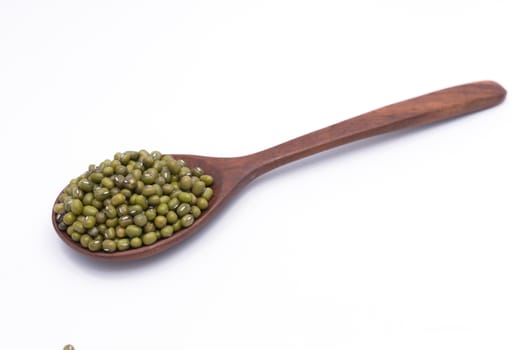 Mung beans over wooden spoon on white background