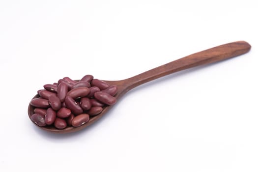 Red kidney beans on a wooden spoon isolate on white background