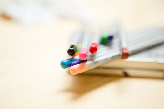 Close up of color pencils with different color over wodden background