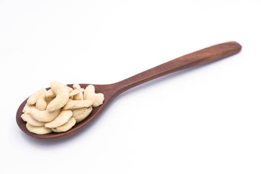 Heap of dried cashew (cashew, nuts, nut) on wooden spoon on  white background