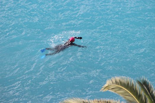 Nice, France - November 30 2015: Woman swimming in the Mediterranean Sea in winter in Nice, France