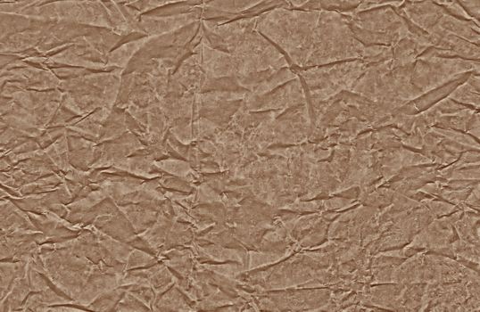 A sheet of brown grainy clear creased parchment paper, interesting background and texture. Horizontal view.