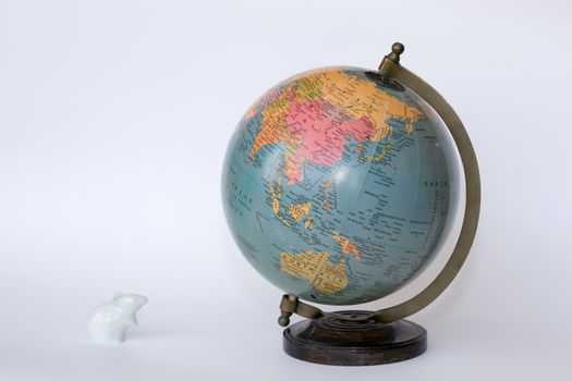 Porcelain mouse staring at a globe