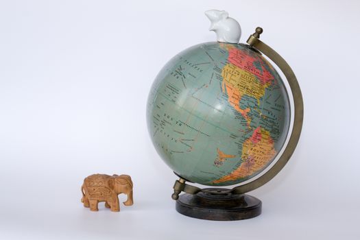 Globe with an wooden elephant and a porcelain mouse