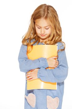 Beautiful little girl in blue dress with copybook. Isolated on white.