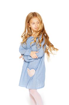 Little girl posing for the camera in blue dress with blond curls