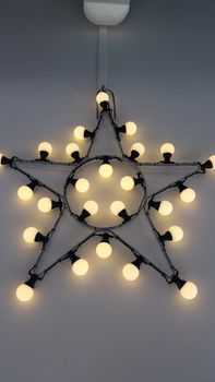 Decorative Star with Lamps on a Background of white Wall. Modern interior