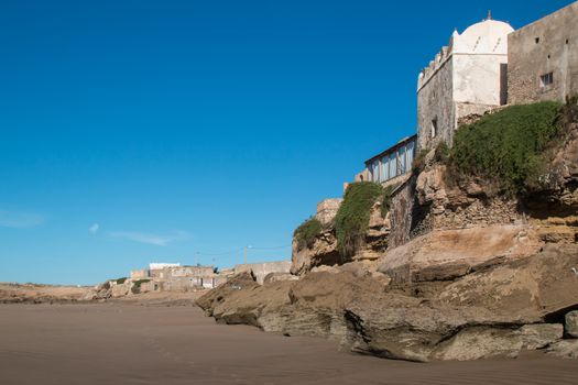 Small mosque in the village on the coast of Atlantic Ocean in Morocco, Moulay Bouzerktoun. Bright blue sky.