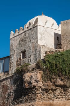 Small mosque in the village on the coast of Atlantic Ocean in Morocco, Moulay Bouzerktoun. Bright blue sky.