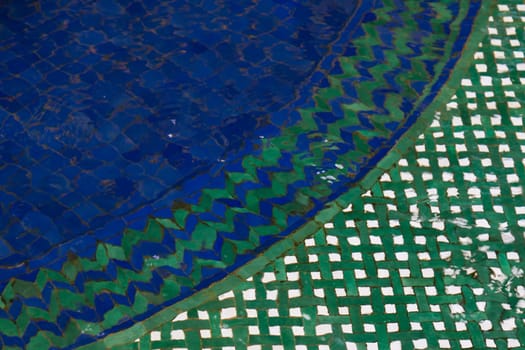 Detail of a bottom of a small pool with mosaic. Clear water.