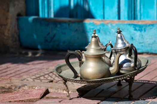 Decoration on the street, small table with traditional arabian tea pots.