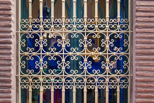 Colorful window with a traditional designed grid. Bricks on the sides.