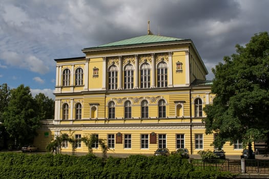 Historical building on the Island of river Vltava in the city center of Prague. Fresh green trees around. Stormy sky.