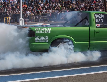 Redding, California: A green truck burns rubber to get better friction for it's tires before a drag race.
Photo taken on: February 13th, 2016