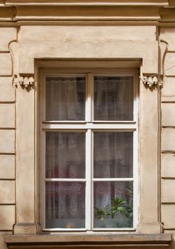 Window of an old house. Courtains and pot with plants.