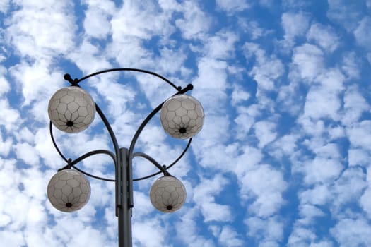 Street lamp in a historical design in the city center of the capital of Czech Republic - Prague. Blue sky with many small clouds in the background.