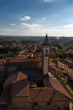 Top view of Vinci Village around meadow area from Conti Guidi Castle in Italy, under bright blue sky background.