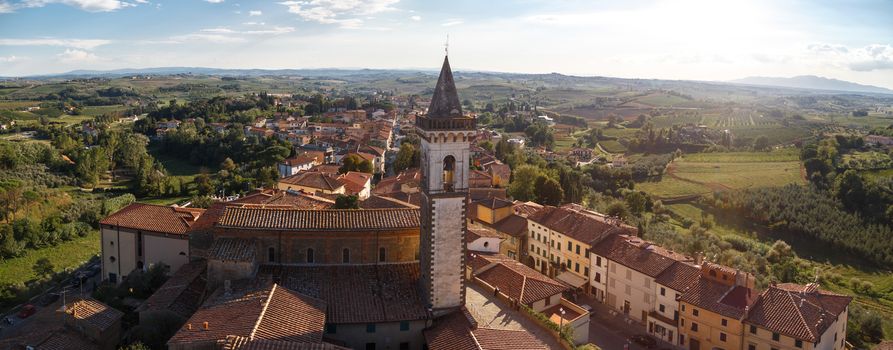 Panoramic top view of Vinci Village around meadow area from Conti Guidi Castle in Italy, under bright blue sky background.