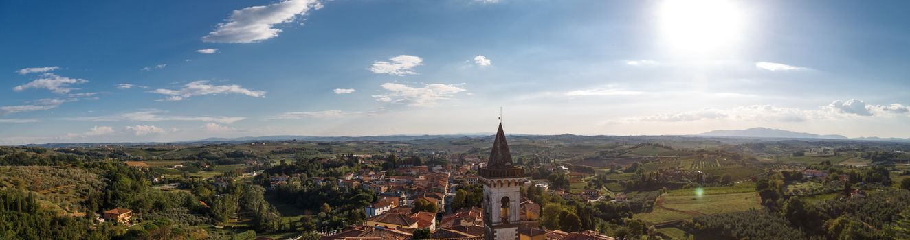Panoramic top view of Vinci Village around meadow area from Conti Guidi Castle in Italy, under bright blue sky background.