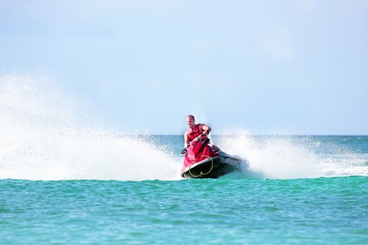 Young guy cruising on a jet ski on the caribbean sea