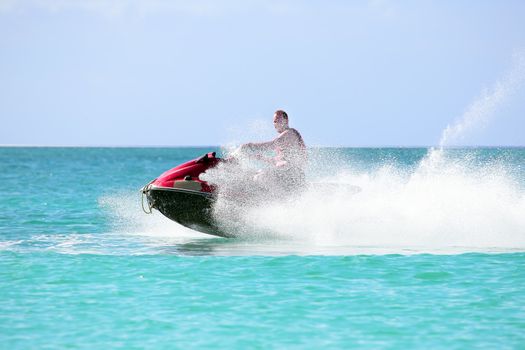 Young guy cruising on a jet ski on the caribbean sea