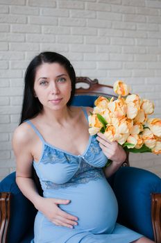 Portrait of the pregnant woman with yellow flowers