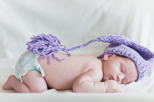 Horizontal portrait of the sleeping baby in purple hat