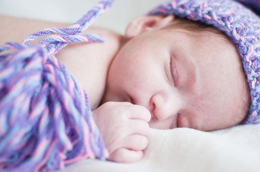 Horizontal portrait of the sleeping baby in purple hat