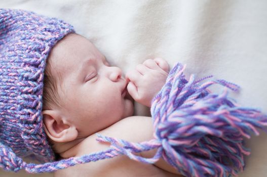 Horizontal portrait of the sleeping baby in purple hat