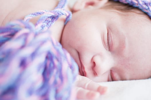 Horizontal portrait of the sleeping baby in purple hat