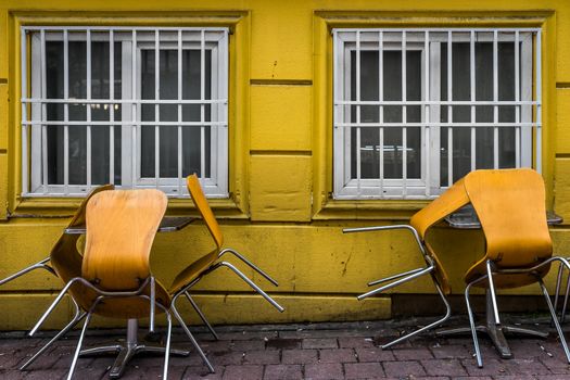 A shot of chairs leaned against the table indicating that the restaurant is not yet open.