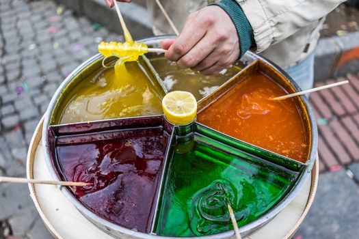 A shot of a person preparing sticky candy on a stick.