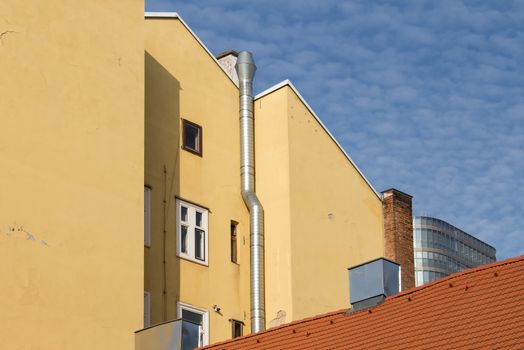 Detail of the traditional, but perfectly rebuilt buildings in Vienna. In a background a part of a modern architecture. Cloudy blue sky.