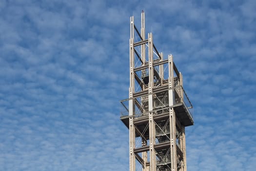 Unusual construction of the tower in Vienna, close to the new Central Railway Station. Blue sky with many white clouds in the background.