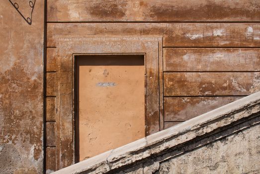 Typical terracotta color of the buildings in italian Rome. Details of an architecture, touched by time. Decorative window.