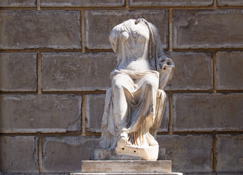 Statue of a woman in antique dresses, preserved just headless.