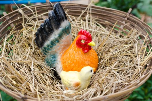 Statue of chickens on a pile of straw.