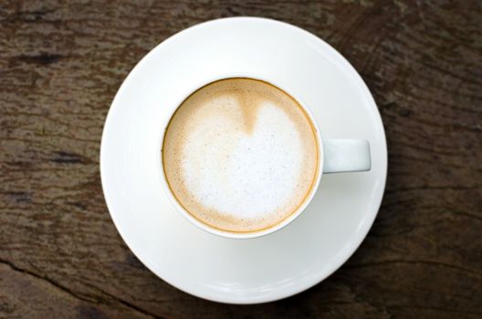 Cup of coffee on wooden table, bird eye view.