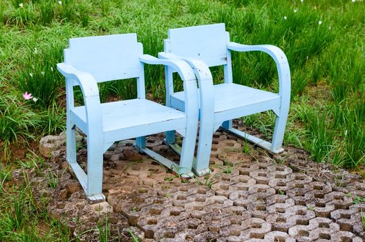 Blue wooden lawn chairs in the spring garden.