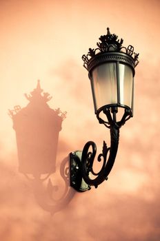 Vintage lantern and shadow on a wall.