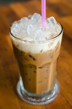 Thailand's traditional iced coffee on a wooden table.